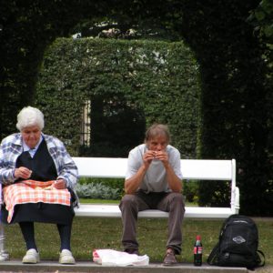 Menschen im Schlosspark auf Parkbank
