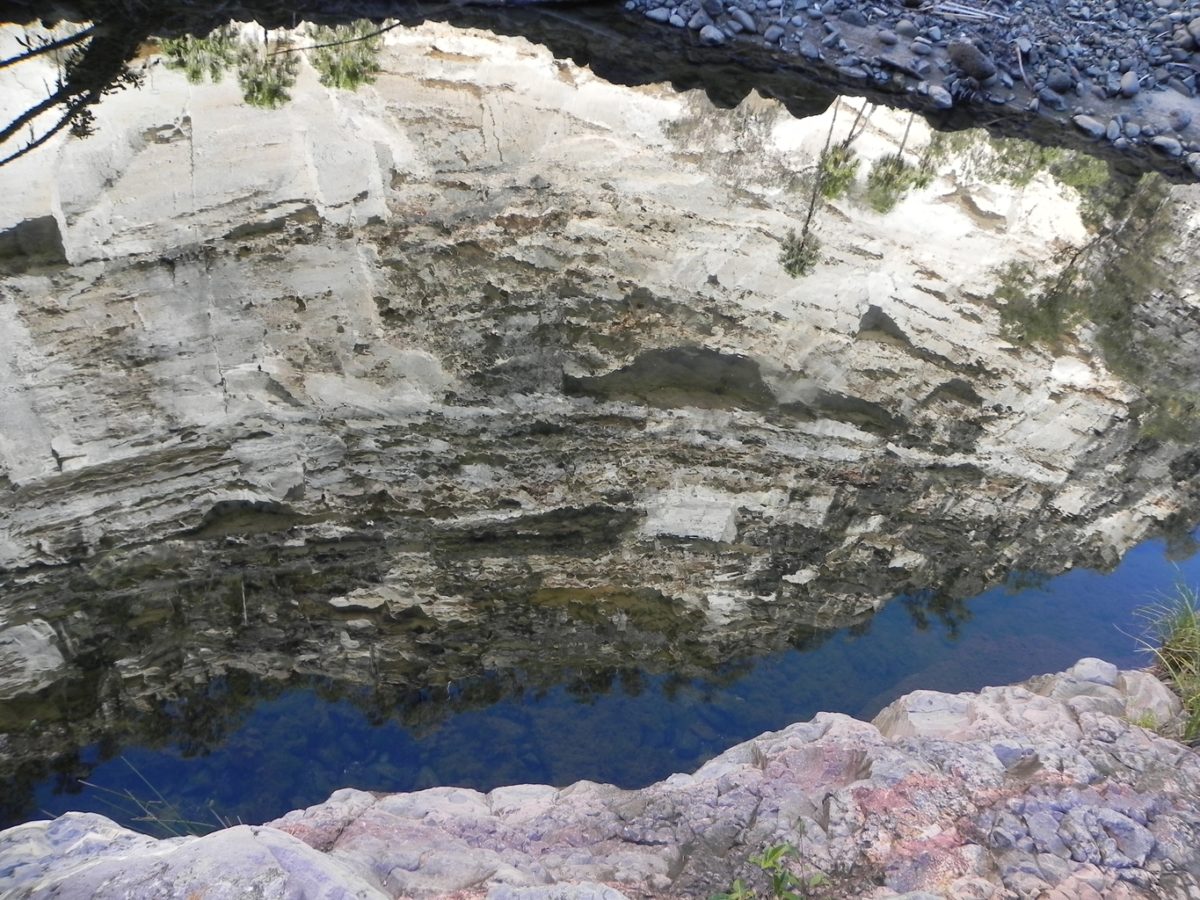 Rock wall mirrored in the river water