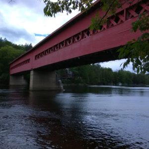Blick auf rote überdachte Holzbrücke