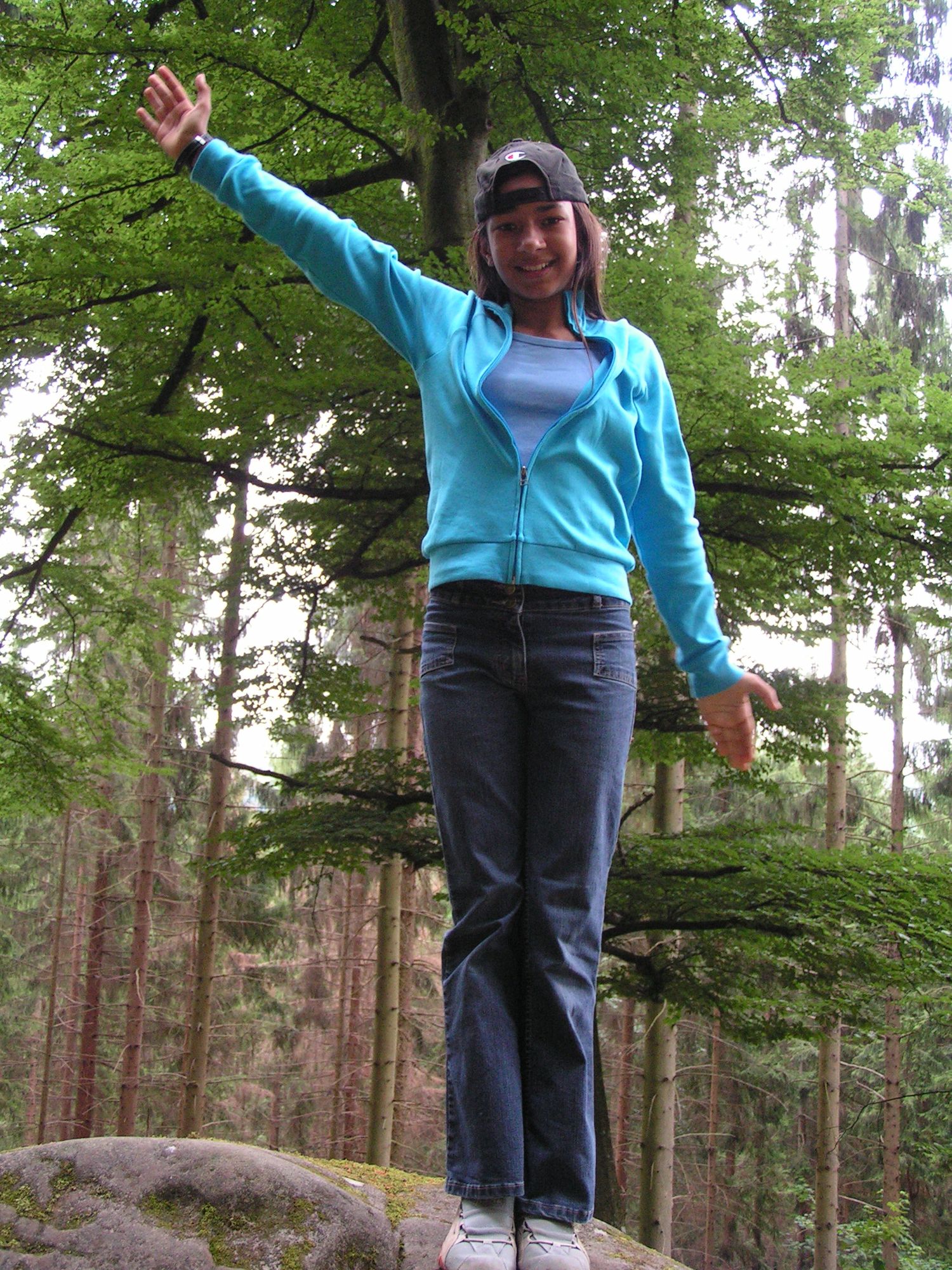 Sophia posiert auf einem Stein im Wald