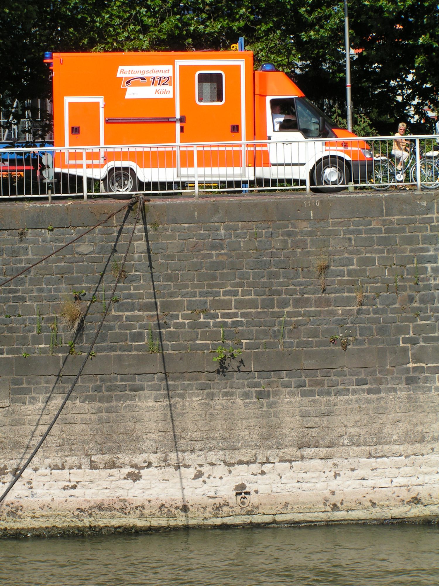 Kaimauer und Rettungsdienst Auto in Köln vom Rhein aus gesehen