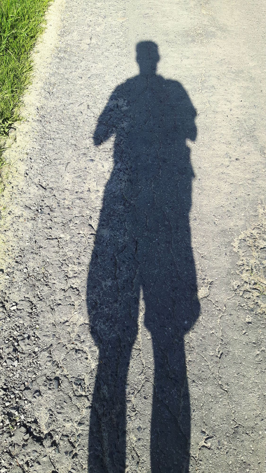 Schatten eines Mannes auf der Teerstrasse