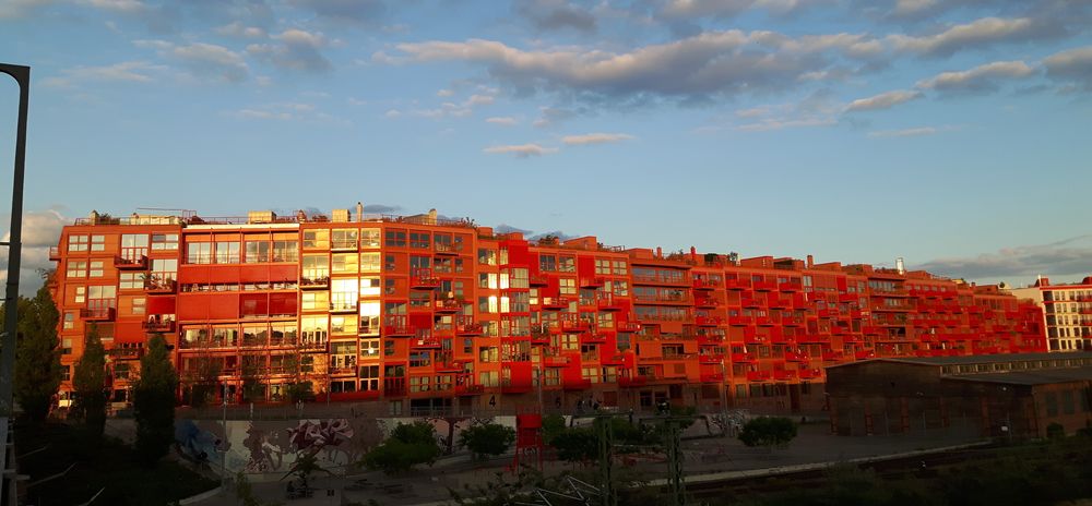 roter Neubaublock Wohnhaus am Gleis