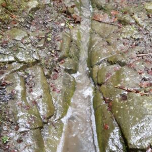 Regenwasser auf altem Weg in Steinrinne