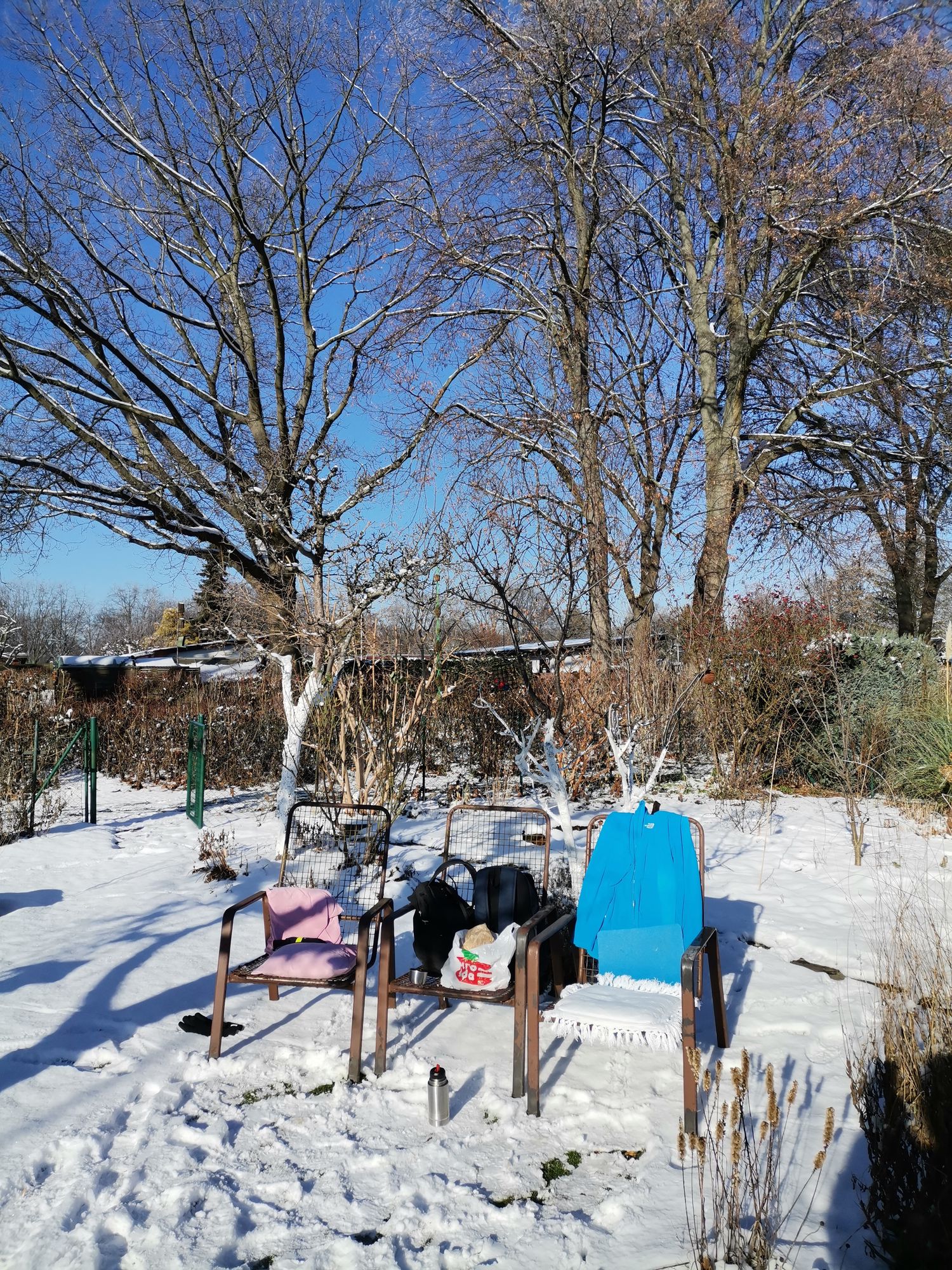 Unsere Stühle im Schnee mit Sonne in der Laube