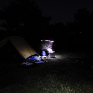 Kochen mit Stirnlampe vor dem Zelt im Dunklen